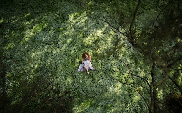 Vrouw, zittend op het gras van boven gezien