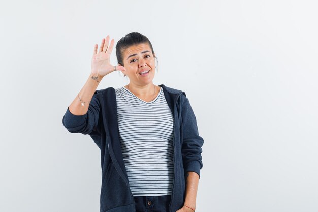 Vrouw zwaaiende hand om afscheid te nemen in t-shirt