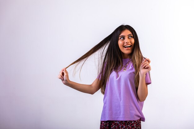 Vrouwelijk model dat haar hand op haar haar legt.