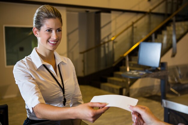 Vrouwelijk personeel kaartje geven aan passagier