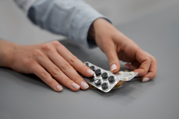 Gratis foto vrouwelijke apotheker die pillen in de apotheek controleert