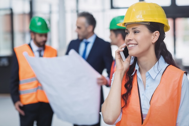 Vrouwelijke architect praten op mobiele telefoon