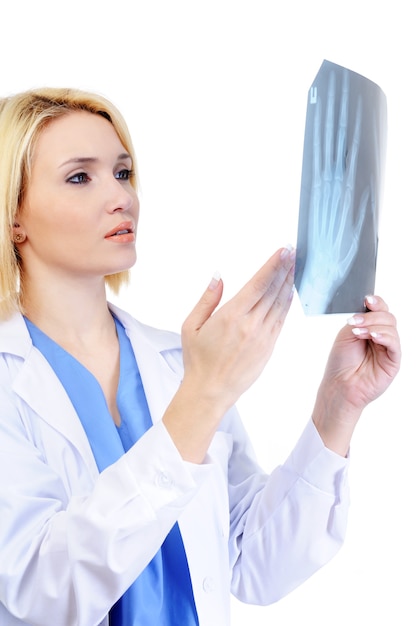Vrouwelijke arts die de medische x-ray toont - die op wit wordt geïsoleerd