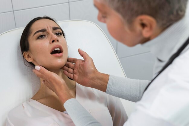 Vrouwelijke arts die de mond van een patiënt controleert