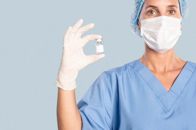 Vrouwelijke arts die een vaccinfles houdt