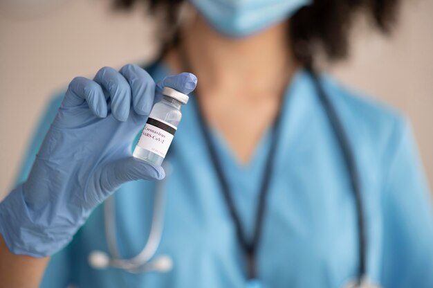 Vrouwelijke arts die het vaccin voor een patiënt voorbereidt
