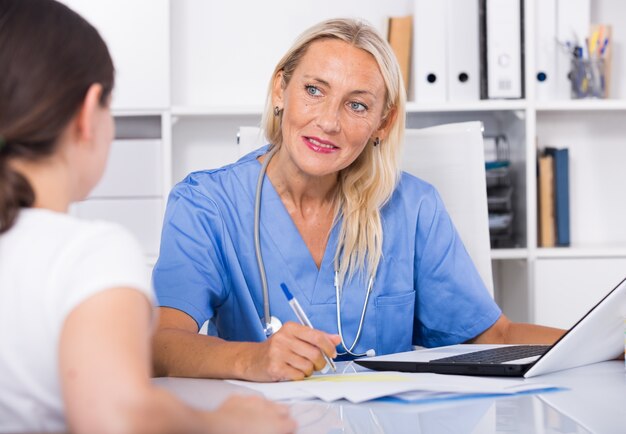 Vrouwelijke arts die naar klachten van patiënten luistert