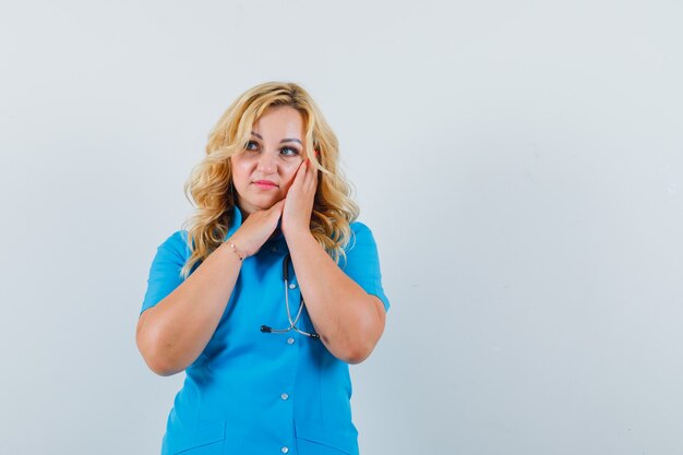Vrouwelijke arts in blauw uniform kussen gebaar maken