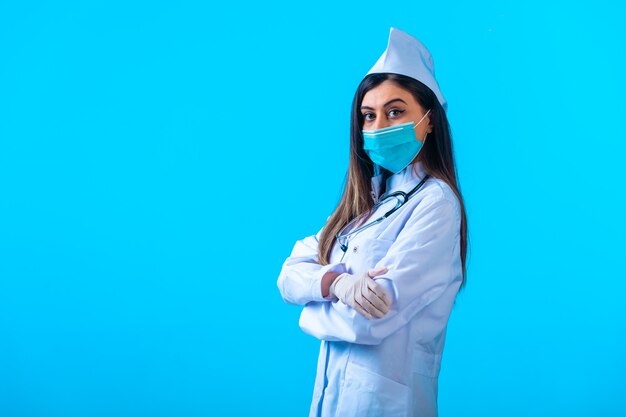 Vrouwelijke arts in masker doet zich voor als een professional.
