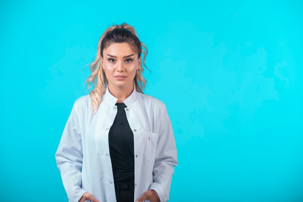 Vrouwelijke arts in wit uniform in professionele houding.