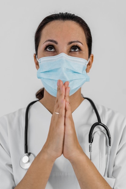 Vrouwelijke arts met een stethoscoop bidden