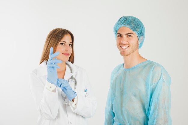 Vrouwelijke arts met handschoenen naast lachende patiënt