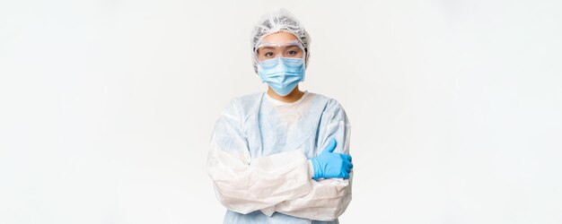 Vrouwelijke aziatische arts of verpleegster in persoonlijke beschermingsmiddelen van het coronavirus staat klaar en