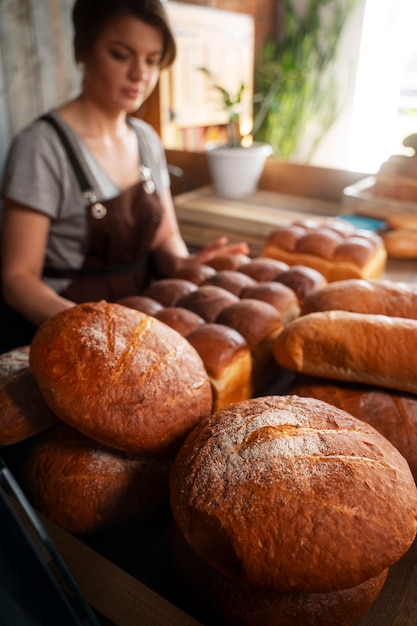Gratis foto vrouwelijke bakker met gebakken brood in de patisserie