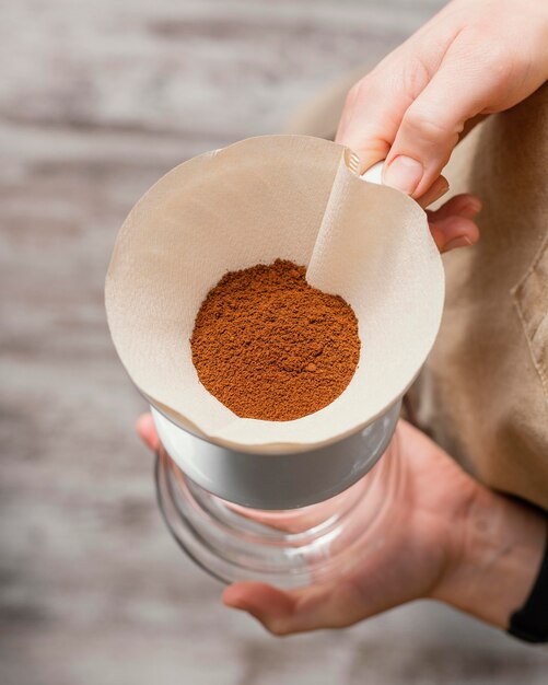 Vrouwelijke barista koffiefilter houden over kruik