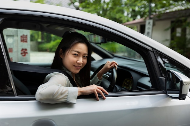 Vrouwelijke bestuurder poseert in een elektrische auto