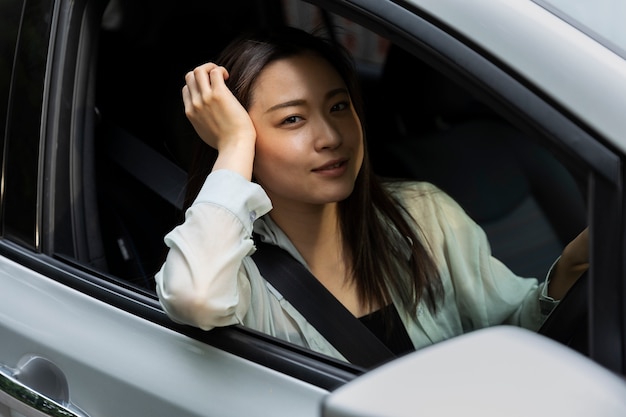 Vrouwelijke bestuurder poseert in een elektrische auto
