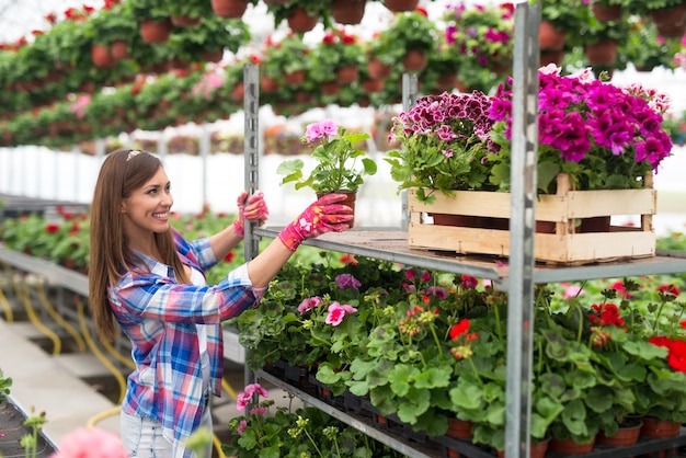 Vrouwelijke bloemist die in bloemenwinkel werkt