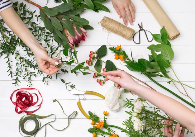 Vrouwelijke bloemist die mooi boeket maakt bij bloemenwinkel