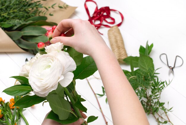 Vrouwelijke bloemist die mooi boeket maakt bij bloemenwinkel