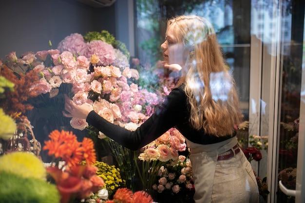 Vrouwelijke bloemist maakt een prachtig arrangement van bloemen