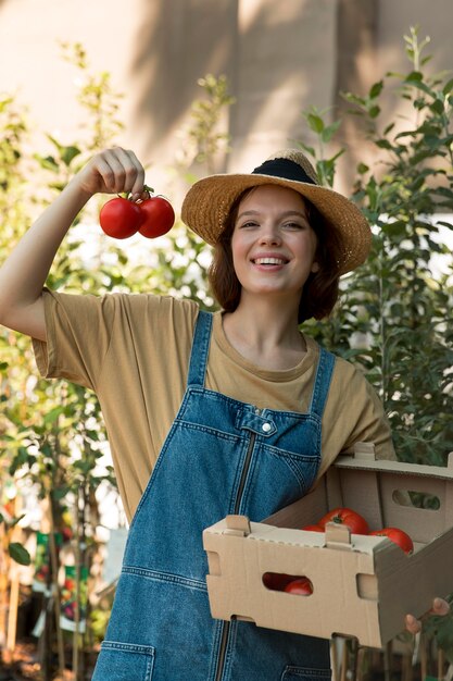 Vrouwelijke boer die wat tomaten vasthoudt