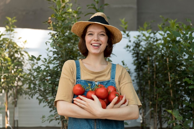 Vrouwelijke boer die wat tomaten vasthoudt