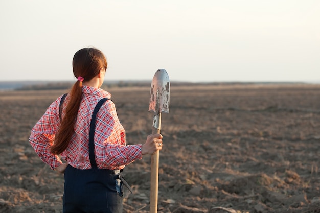 Vrouwelijke boer in geploegd veld