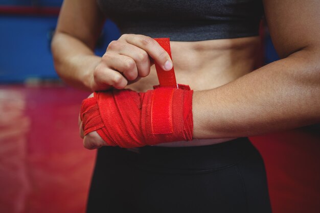 Vrouwelijke bokser die rode riem om pols draagt