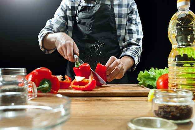 Vrouwelijke chef-kok die verse groenten snijdt