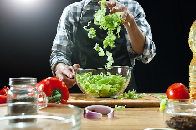 Vrouwelijke chef-kok die verse groenten snijdt