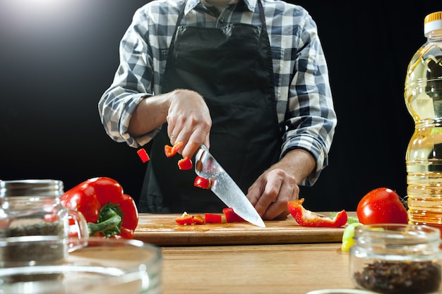 Vrouwelijke chef-kok die verse groenten snijdt