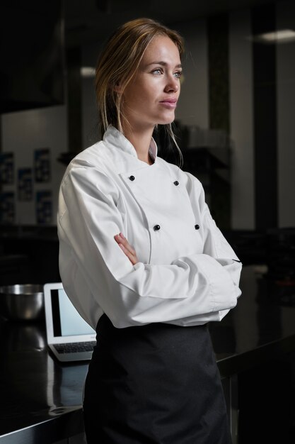 Vrouwelijke chef-kok in de keuken gekleed in schort en uniform