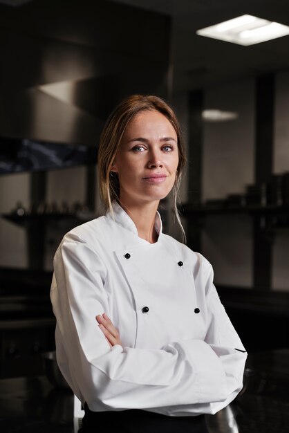 Vrouwelijke chef-kok in de keuken gekleed in schort en uniform