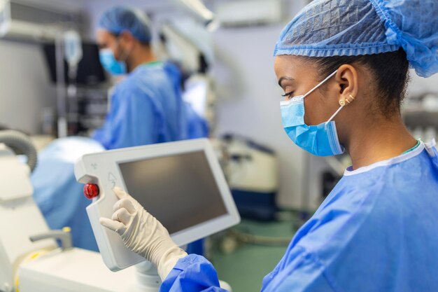 Vrouwelijke chirurg met chirurgisch masker in operatiekamer met behulp van 3D-beeldgeleide chirurgiemachine