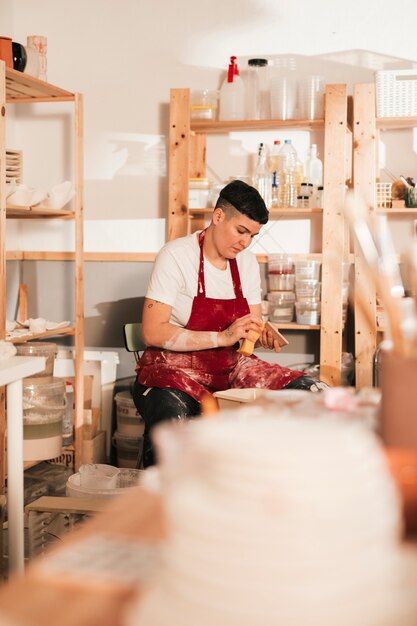 Vrouwelijke craftswoman die de keramische tegels met spons schoonmaakt