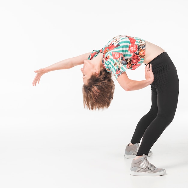 Vrouwelijke danser die tegen witte achtergrond uitoefent