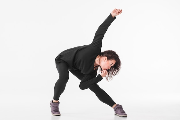 Gratis foto vrouwelijke danseres poseren tegen een witte achtergrond