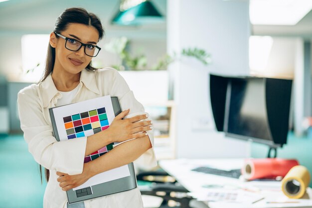 Vrouwelijke digitale ontwerper kijkt naar stalen op kantoor
