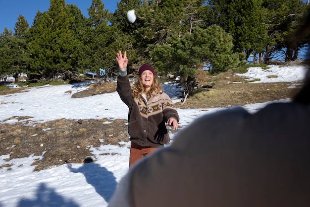 Gratis foto vrouwelijke geliefden spelen en gooien sneeuwballen naar elkaar tijdens de winterreis