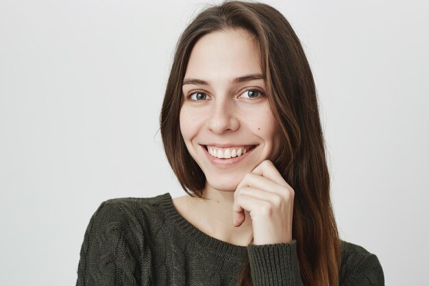 Vrouwelijke glimlachende gelukkige vrouw die camera kijkt