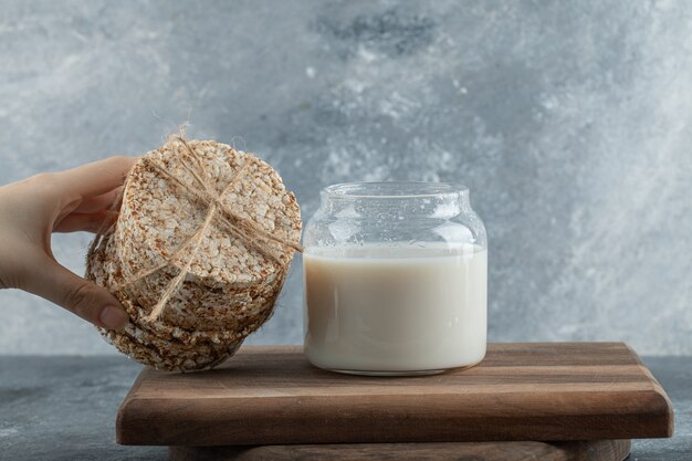 Vrouwelijke hand met stapel knäckebröd op houten bord