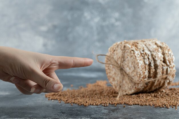 Vrouwelijke hand wijzend op heerlijke rijstwafel op marmeren oppervlak