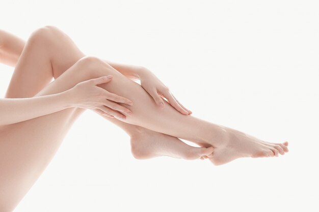 vrouwelijke handen over de benen, huid lichaamsverzorging concept