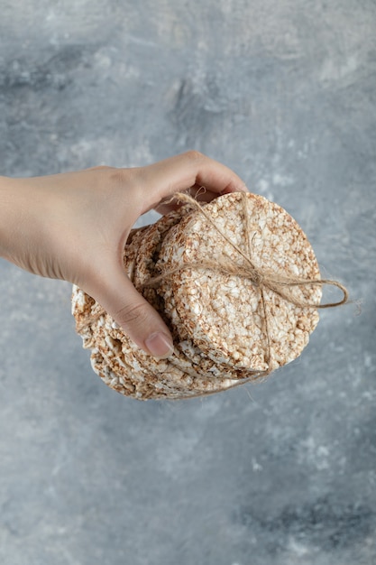 Vrouwelijke handholding stapel rijstwafels op marmeren oppervlak