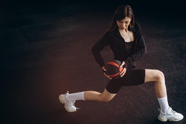 Vrouwelijke instructeur die met een bal in de sportschool traint