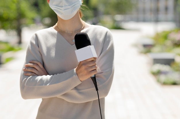 Gratis foto vrouwelijke journalist met medisch masker