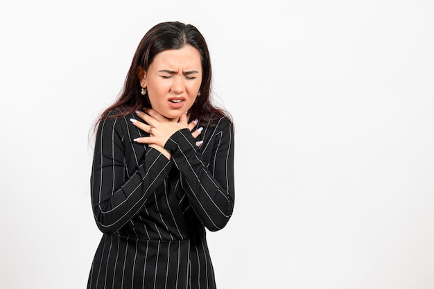 vrouwelijke kantoormedewerker in strikt zwart pak met ademhalingsproblemen op wit