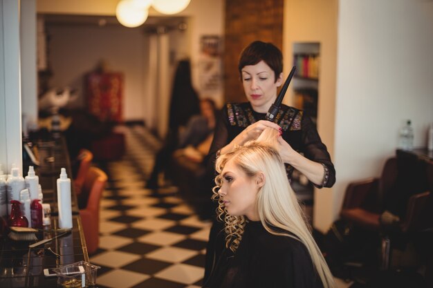 Vrouwelijke kapper styling klanten haar