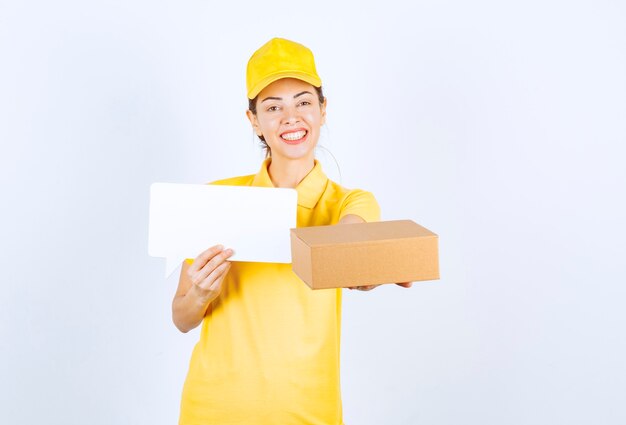 Vrouwelijke koerier in geel uniform die de bestelling aan de klant aanbiedt en het certificaat van echtheid presenteert.